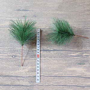 18cm artificial green pine needles with wire stem measured on a wooden background