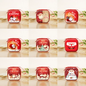 Red Christmas coin purses with festive patterns and lanyards on a wooden background