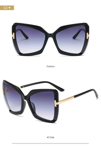 Detail view of butterfly frame sunglasses with purple gradient lenses and gold T-hinges