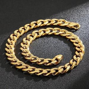 Polished 18K gold plated Cuban link chain necklace on textured black background