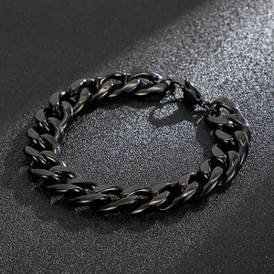 Detailed view of a black stainless steel Cuban link bracelet on a textured background