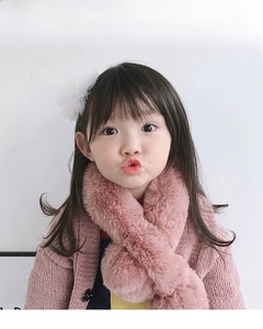 Detail of pink plush scarf and Christmas reindeer antler hair clip on a child model
