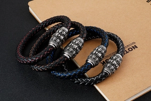 Detailed stack of woven leather skull bracelets with vintage silver metal hardware