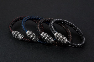 Detail of multi-color braided leather bracelets with skull-shaped metal buckles