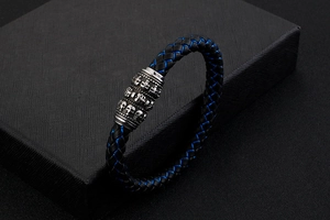 Detail of blue and black woven leather bracelet with silver skull clasp in a premium gift box