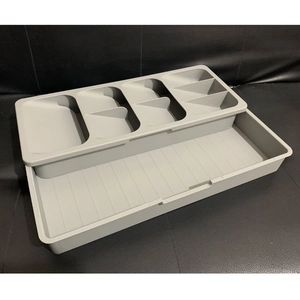 Macro view of modular light grey kitchen drawer organizer with layered dividers for cutlery