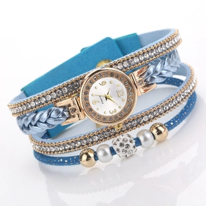 Detail van blauw meerlaags wikkelhorloge met glinsterende strass-steentjes en parels