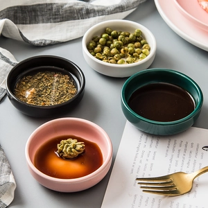 Set of four colorful ceramic seasoning dishes for sauces and snacks in a top-down view
