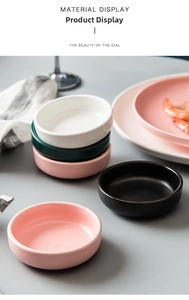 Detailed ceramic sauce dish set in matte pink and green within a modern table setting