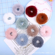 Flat lay of colorful plush hair scrunchies in purple, pink, and blue for autumn and winter