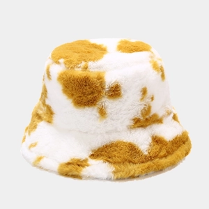 Detail showing the fluffy yellow and white cow print texture of this plush bucket hat
