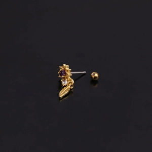 Detail of flower stud earring with purple gems and gold leaf pendant on black background