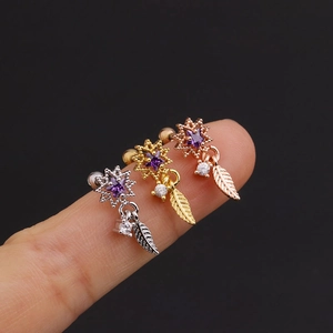 Three colorful zircon star earrings in silver gold and rose gold on a black background
