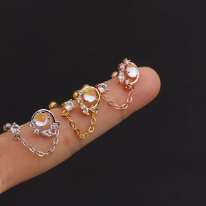 Detail of crescent moon and star earrings with colorful zircon and fine chains