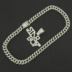 Close-up of silver Cuban chain necklace with iced-out SIN BOY rhinestone pendant