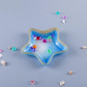 Star-shaped resin tray with blue-white gradient and gold glitter edges holding gemstones