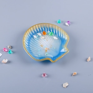 Detailed top view of seashell shaped resin tray with blue gradient and gold rim