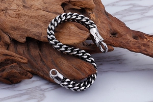 Close-up of titanium steel braided chain bracelet with round spring clasp on wood