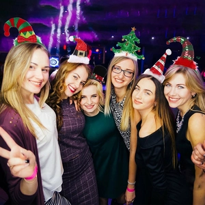 Festive Christmas headbands featuring Santa hats and trees worn by a group at a party