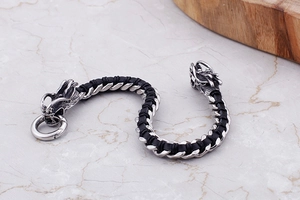 Detail of vintage double dragon head clasp on black braided leather motorcycle bracelet