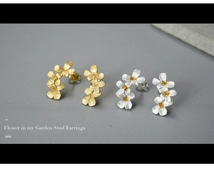 Macro detail of matte S925 sterling silver flower stud earrings with gold center