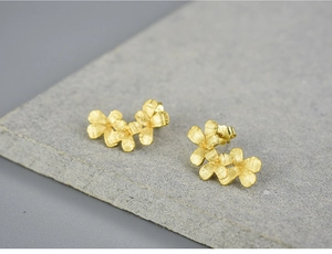 Macro shot of S925 sterling silver stamp on matte gold floral stud earrings
