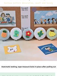 Detail view of mini retractable tape measures with cute 3D cartoon motifs in a warm setting