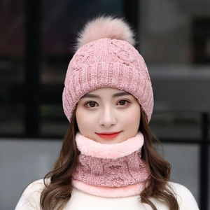 Dettaglio del set cappello e sciarpa in maglia di ciniglia rosa con pompon in ecopelliccia