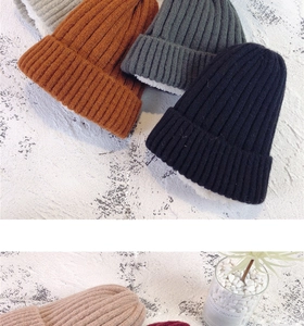 Macro shot showing diverse colors of thick knitted beanies with warm fleece lining inside