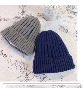 Detail of thick knitted winter beanies in grey and navy with fleece lining for warmth