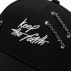 Black cotton baseball cap with white Keep The Faith embroidery and metal ring details