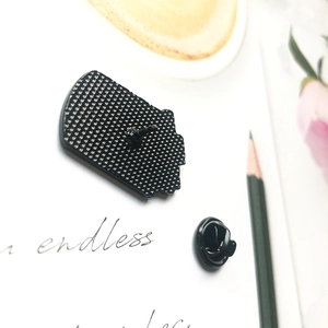 Cute black cat enamel pin with rubber clutch on minimalist desk background