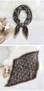 Detail of pleated coffee silk scarf featuring white paisley pattern and wavy edges