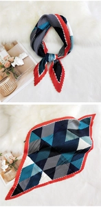 Detail showing red and blue geometric pleated silk scarf on plush white background