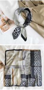 Detail of leopard and geometric print silk scarf styled with a classic khaki trench coat