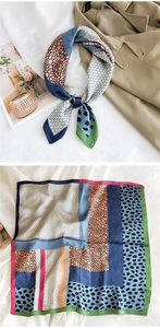 Detail of silk scarf with geometric patterns and leopard print on a trench coat