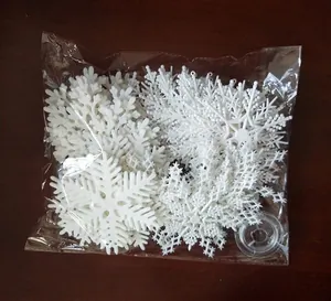 Set of 4 white plastic 10cm Christmas snowflakes with clear hanging string in packaging