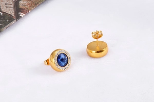 Details von goldenen Kristall-Ohrsteckern mit blauen Edelsteinen und Zirkonia-Besatz