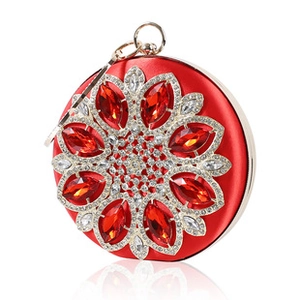Macro detail of red satin evening clutch with sparkling floral rhinestone embellishments