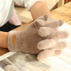 Detail of knitted winter touchscreen gloves featuring a cute bear leather patch