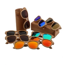 Collection of wooden sunglasses with colorful reflective lenses on bamboo display stands