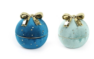Close-up of spherical velvet jewelry boxes with gold bows and sparkling star patterns