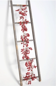 Vue verticale d'une guirlande de baies rouges de 2m sur une échelle en bois rustique
