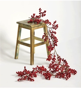 Détail d'une guirlande de baies rouges de 2m suspendue sur un tabouret pour décor de Noël