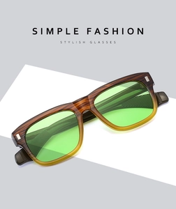 Detail of square sunglasses featuring a brown faux wood grain frame and light green lenses