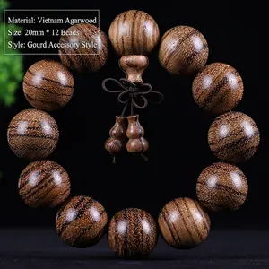 Detail of 20mm Vietnamese agarwood beads with a gourd pendant on black background