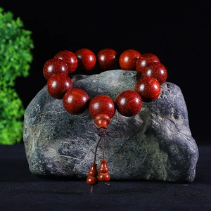 Brazilian rosewood prayer beads on dark rock with carved double gourd pendant