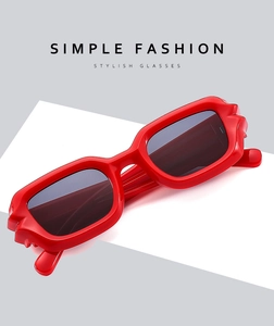 Detailed view of red square frame sunglasses with dark lenses on a minimalist background