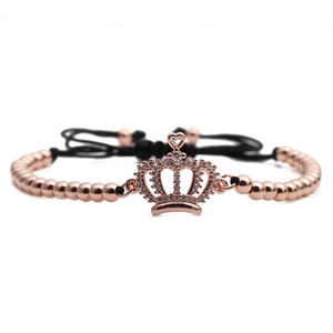 Detail of rose gold crown charm with micro-pave zircons on adjustable beaded bracelet