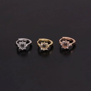 Detailed view of silver, gold and rose gold star huggie earrings with cubic zirconia